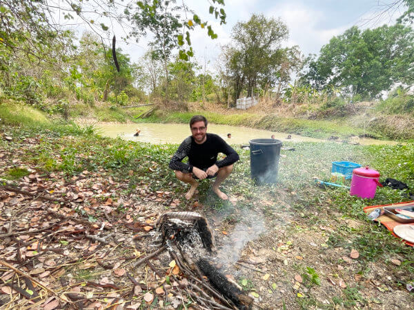 cooking fresh fish next to a small isaan lake